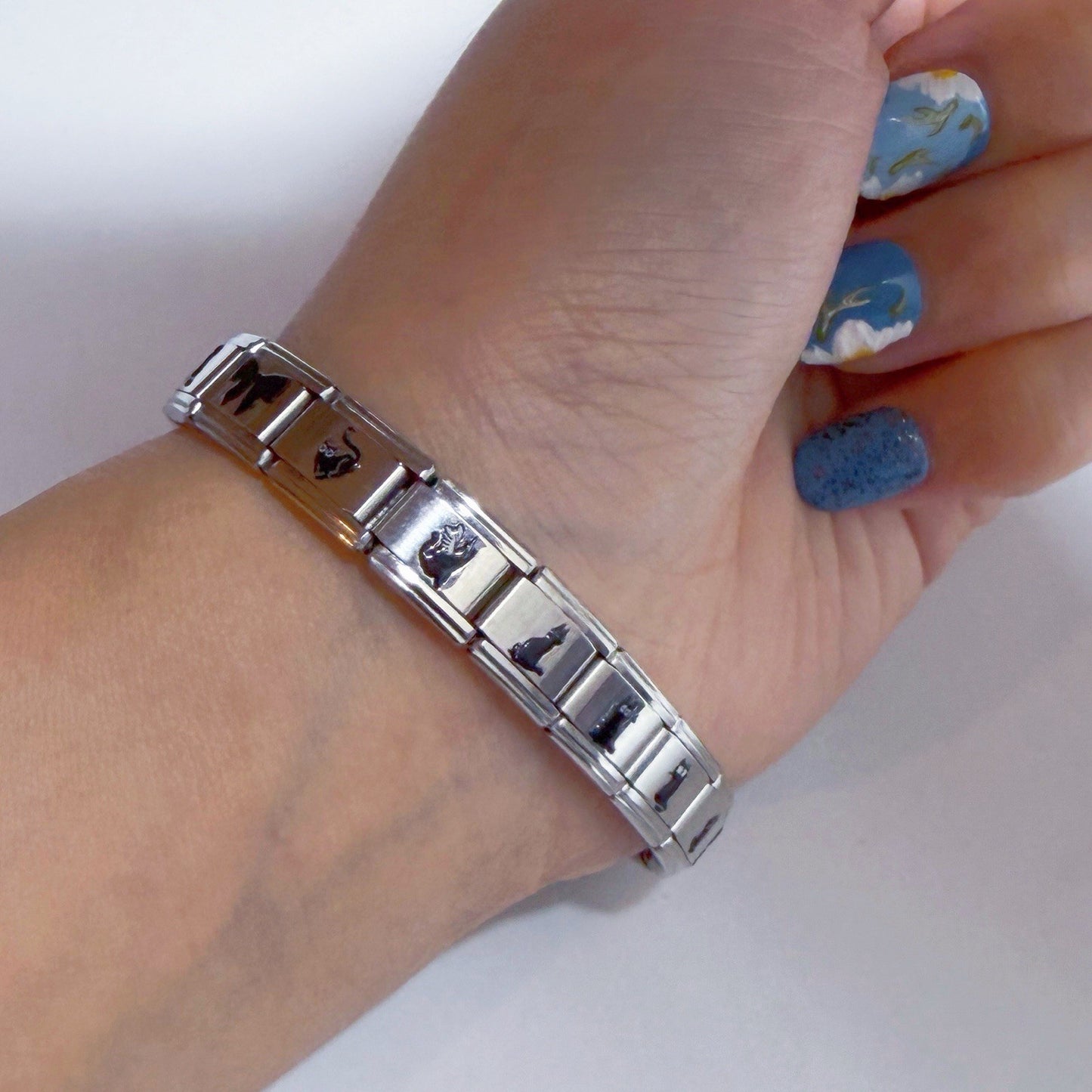 Pami Charms Italian charm bracelet featuring various unique designs on a silver metal band