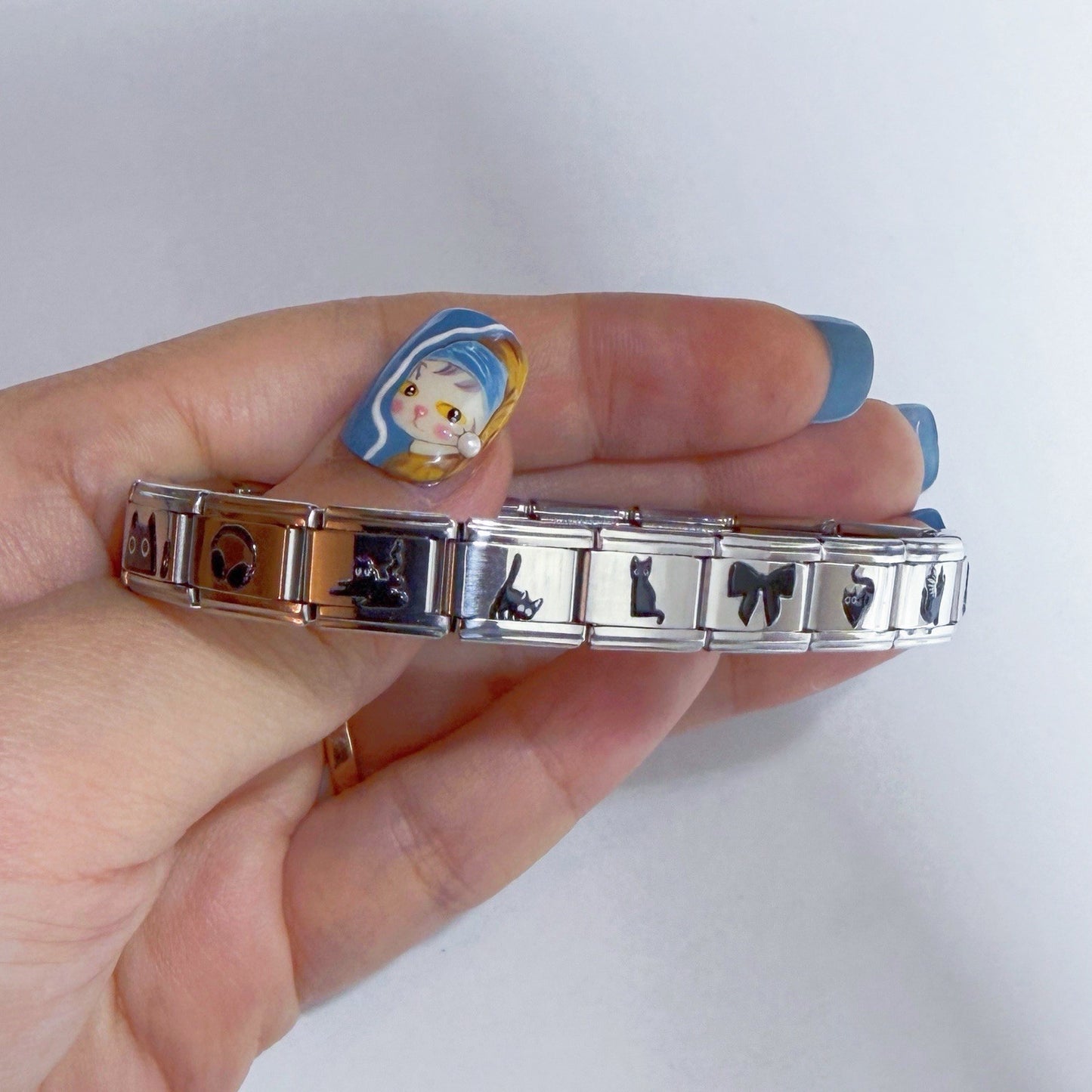 Pami Charms Italian charm bracelet held in hand featuring various decorative designs