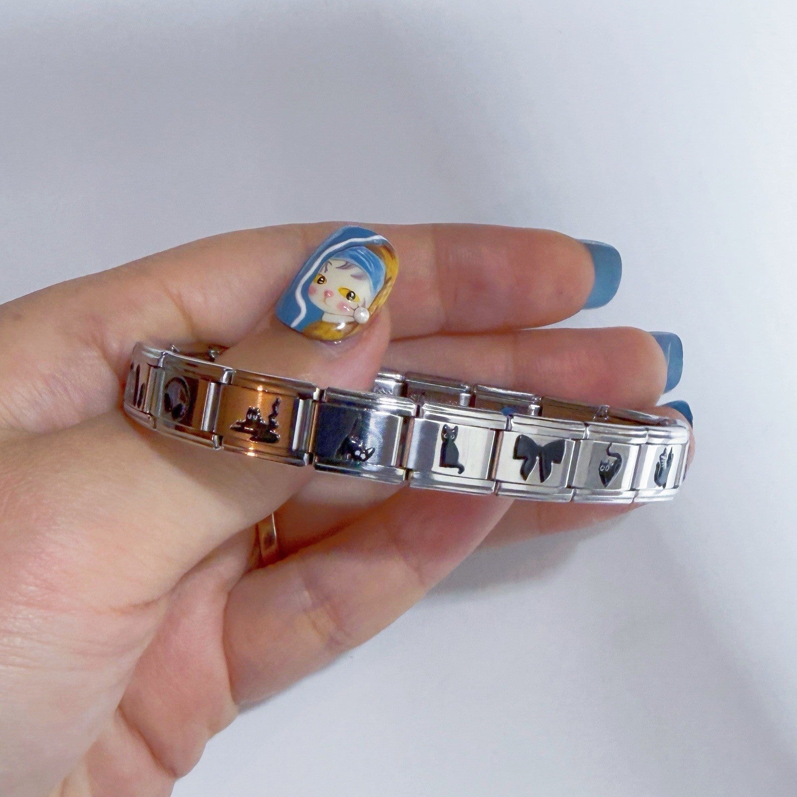 Hand holding a stylish bracelet with Italian charm designs, showcasing vibrant colours and intricate details