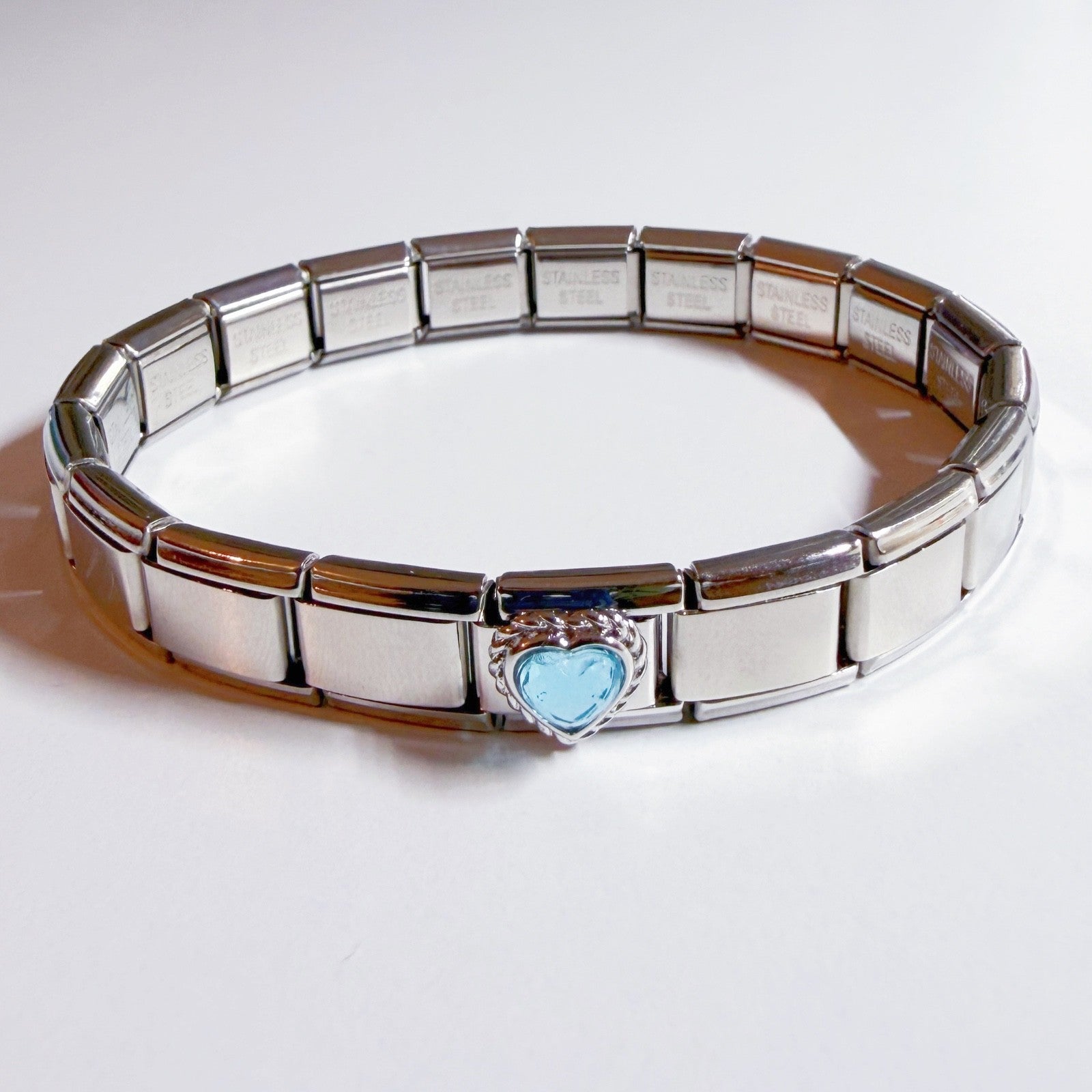 Pami Charms Italian charm bracelet with a heart-shaped blue charm at the centre