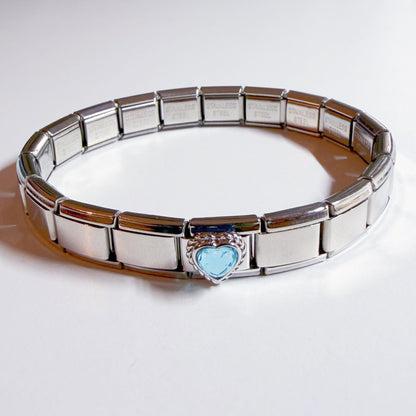Pami Charms Italian charm bracelet with a heart-shaped blue charm at the centre