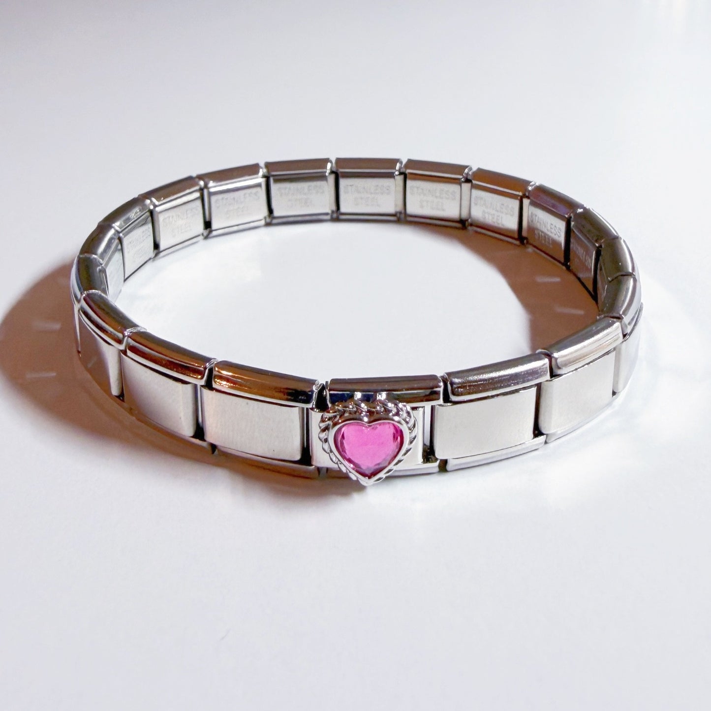 Pami Charms Italian charm bracelet featuring a silver design and a pink heart detail